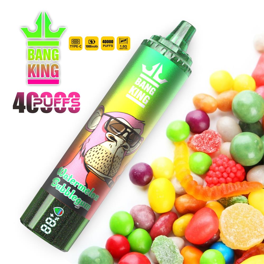 Green metallic disposable vape device labelled BANG KING with a cartoon monkey and 'Watermelon Bubblegum' flavour text, pictured beside a colourful pile of gummy and hard candies and a 40,000-puffs promotional badge